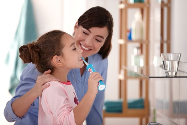 Parent gently cleaning a baby's gums as part of oral care